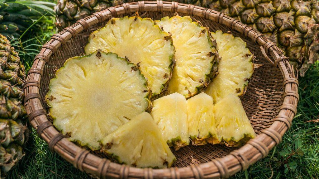 can dogs eat pineapple - sliced fresh pineapple in a wicker basket on grass