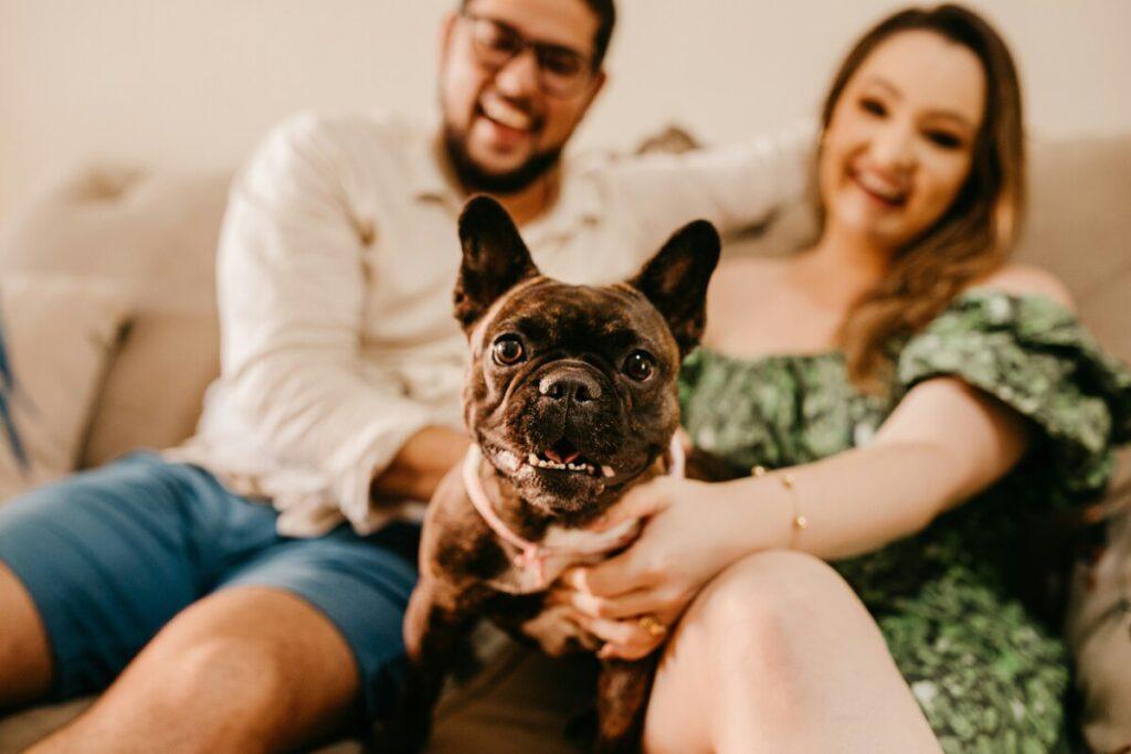 Young couple playing with a hypoallergenic dog at home