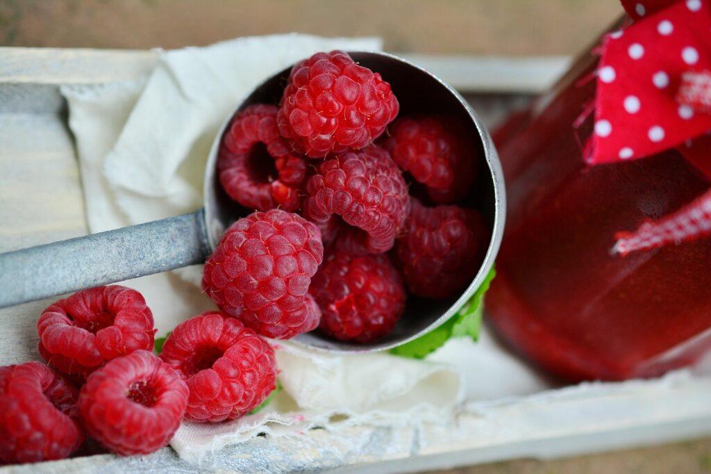 Fresh raspberries in a metal scoop, perfect for discussing if dogs can eat raspberries